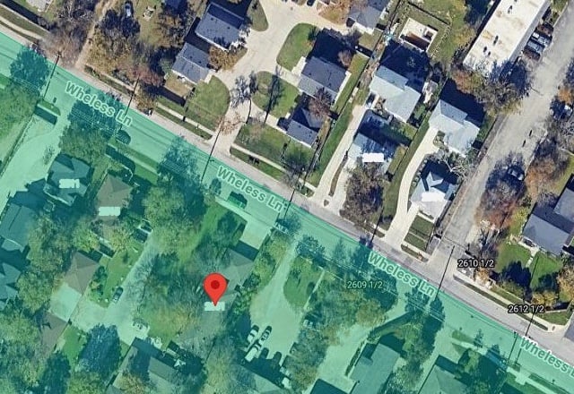 The same satellite frame of Wheless Lane with the pin on 2601 Wheless Ln and the Justice Precinct 5 jurisdiction shaded on the south side of the street