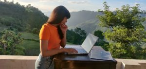woman working outdoors in pristine mountain setting representing a virtual law practice