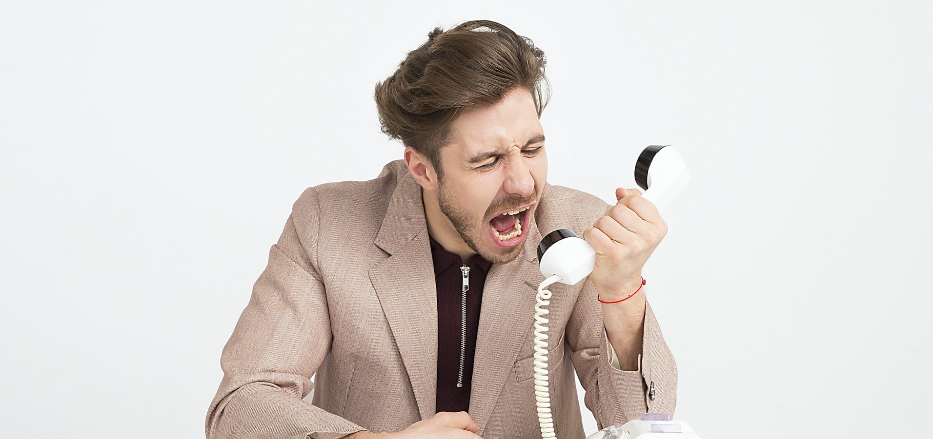 how to deal with difficult legal clients. image: a man in professional clothing yelling angrily into an old-fashioned telephone