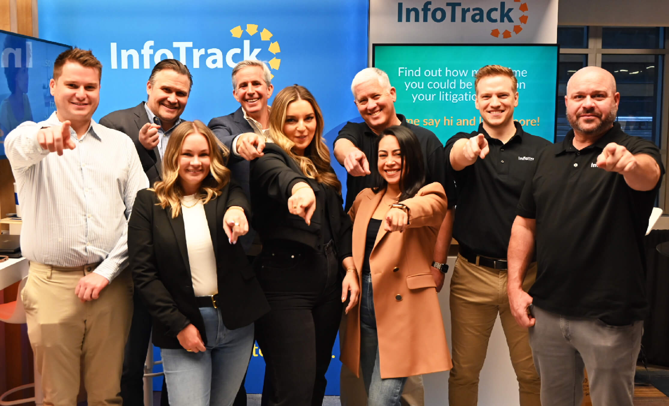 Team members in front of an InfoTrack booth at a trade show